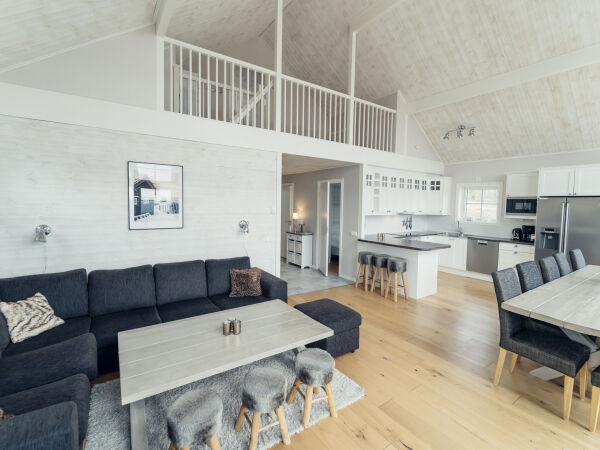Interiörvy av ett modernt vardagsrum med kök och matplats.